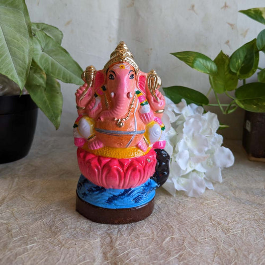 Hand-painted 8-inch Ganesha Golu doll seated on a pink lotus, adorned with ornaments and vibrant colors, perfect for Navarathri decor.