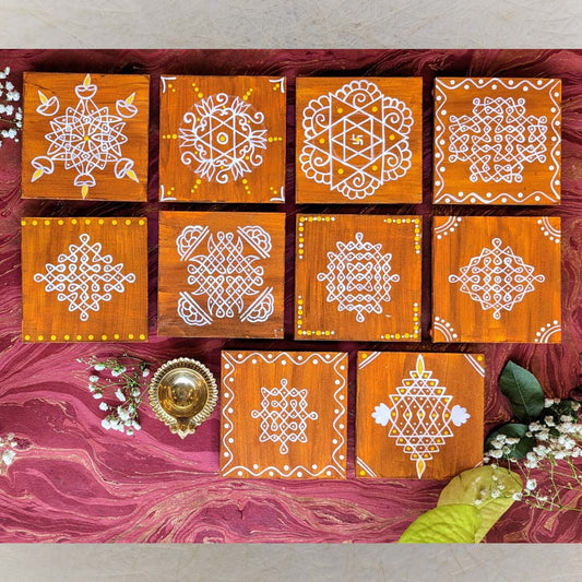 Traditional brown wooden manai set with hand-painted white kolam designs and yellow accents, displayed on a vibrant decorative background.