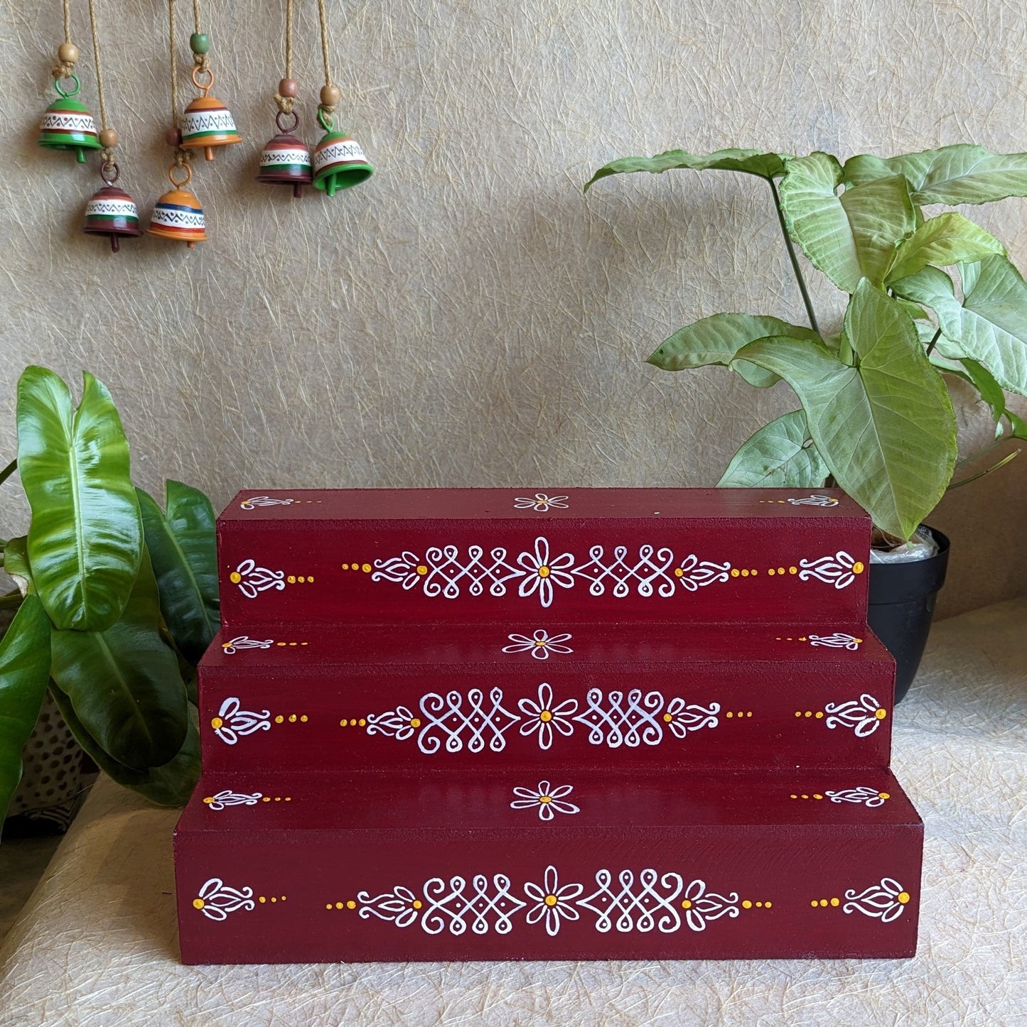 Handcrafted Three-Step Maroon Golu Padi with White Floral Kolam Designs for Festive Decor and Navaratri Displays.