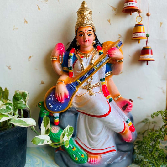 Handcrafted Navarathri Golu doll of Goddess Saraswathi seated with a veena and a peacock.